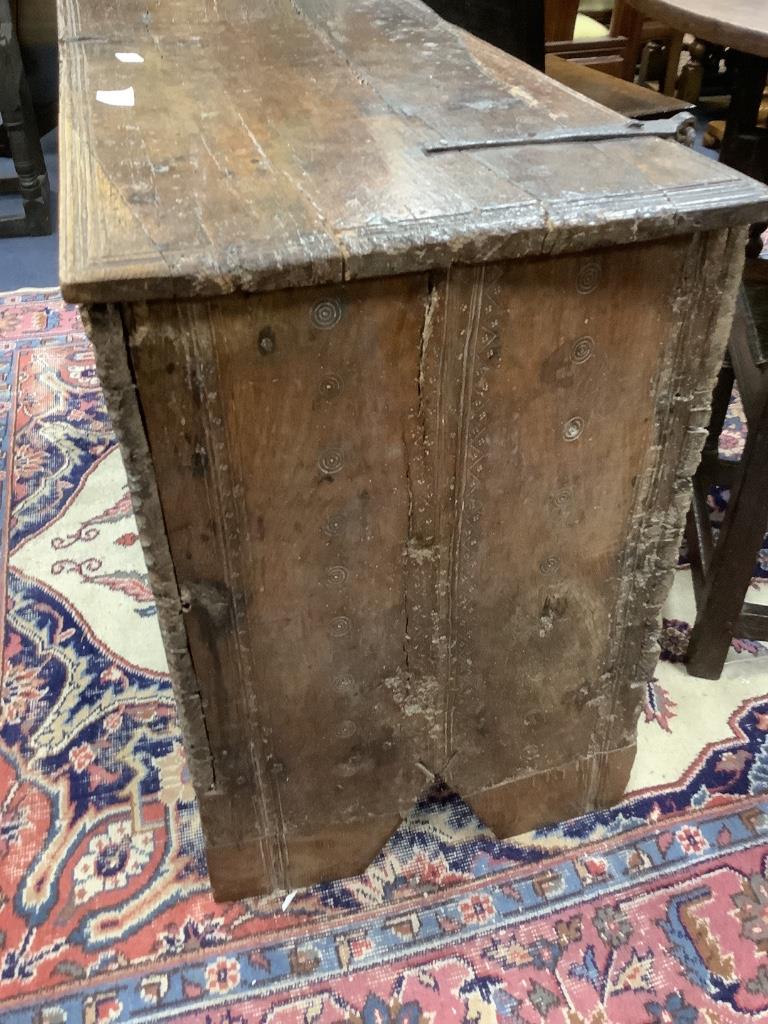 An early English oak six plank coffer, with shallow incised roundels and arched borders, 17th century, width 114cm, depth 50cm, height 72cm